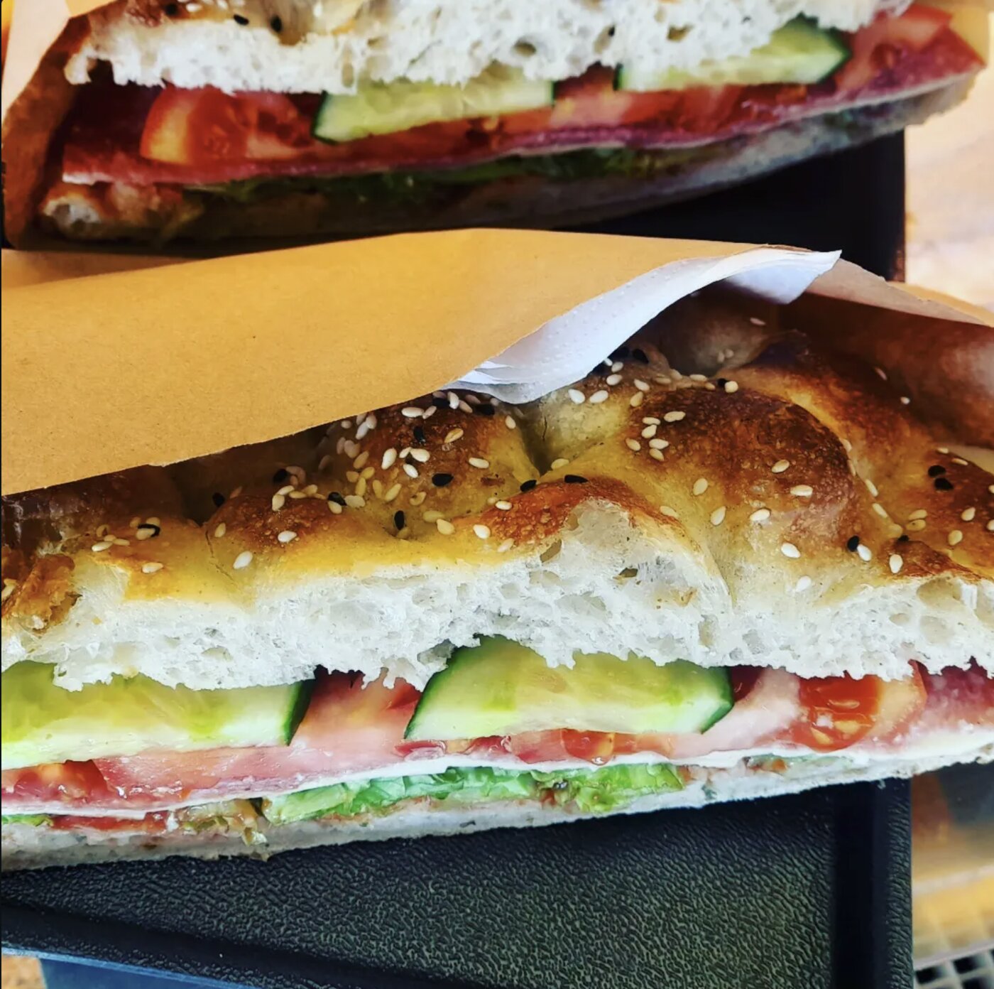 Belegtes Sesambrot mit Salami, Tomate und Gurke